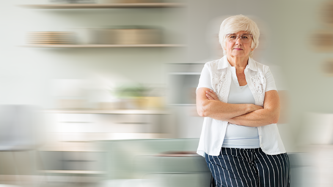 A woman stands with her arms folded, the background is shaking and blurry.