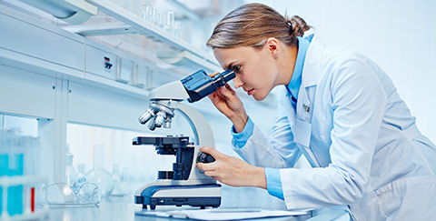 A scientist looking through a microscope
