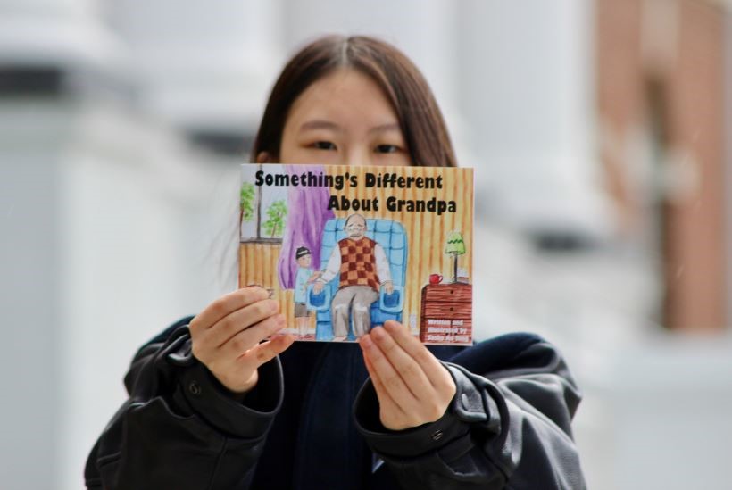 Sasha Au Yong avec un exemplaire de son livre pour enfants sur la maladie de Parkinson